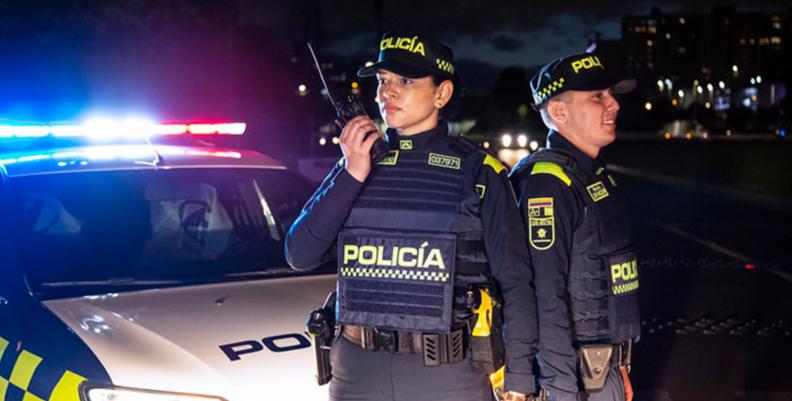 Dos policías frente a una patrulla. 