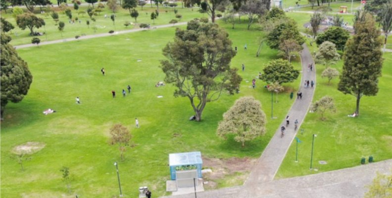 Vista aérea de un parque de Bogotá con zonas verdes y un pasillo de tránsito. 