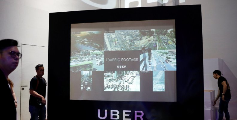 A screen shows the traffic conditions in cities across Asia during an Uber event in Singapore