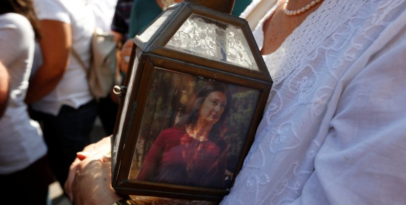 A woman holds a lantern with a picture of investigative journalist Daphne Caruana Galizia, who was assassinated in a car bomb attack, during a protest outside the law courts in Valletta