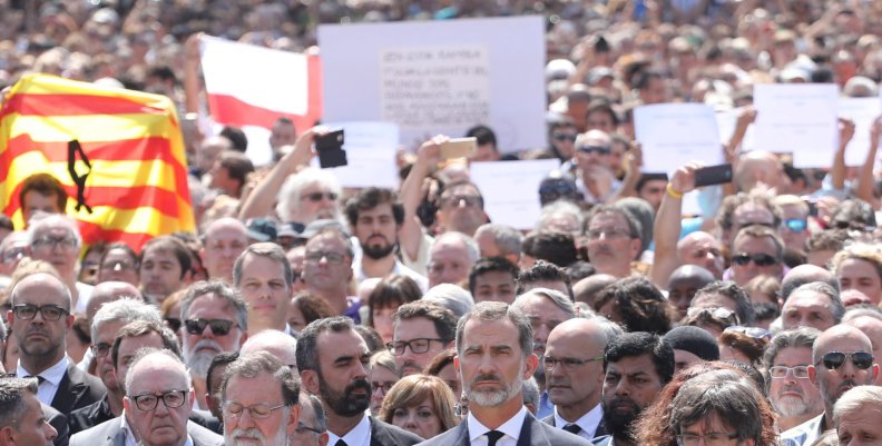 King Felipe of Spain sits between Prime Minister Mariano Rajoy and President of the Generalitat of Catalonia Carles Puigdemont as they observe a minute of silence in Placa de Catalunya in Barcelona