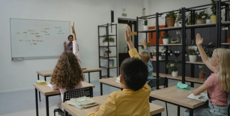 Niños en una salón de clase participando activamente 