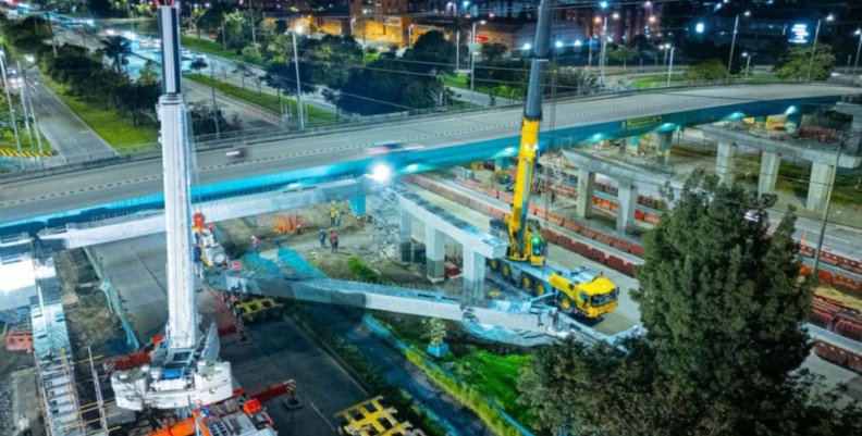 Un puente vehicular de concreto, rodeado de maquinaría de obra