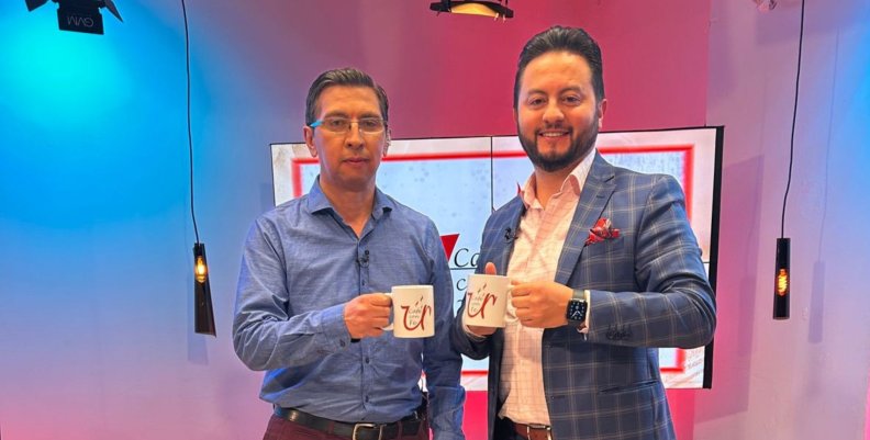 Dos hombres de traje levantando una tasa de café
