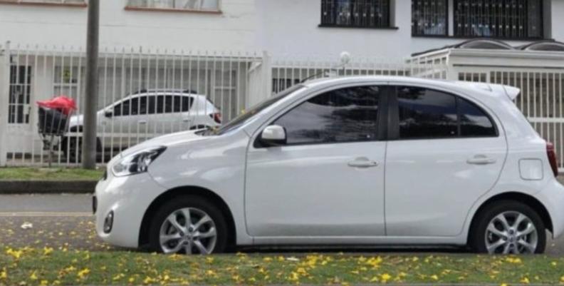 Automóvil blanco parqueado en una acera 