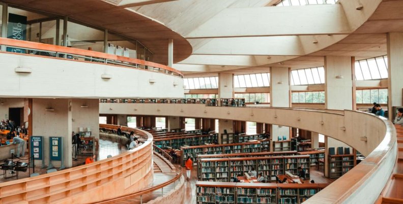 Bibliotecas públicas de Bogotá Pasillos con suelo de madera y paredes blancas: en medio, estantes de libros