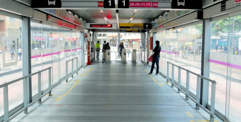 Estación de transMilenio por dentro un pacillo con piso metálico y puertas de cristal a los lados