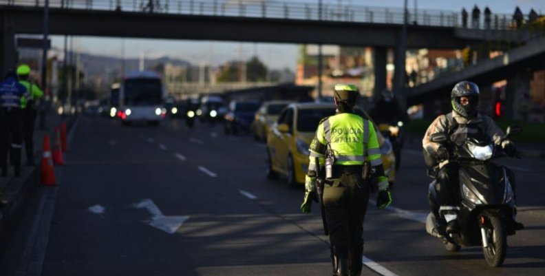 Integrante de la Policía de Tránsito coordinando el plan retorno en una vía principal de la ciudad.