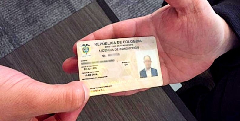 Persona recibiendo la licencia de conducción expedida en Colombia