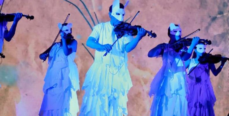 Hombres y mujeres disfrazados como animales tocando instrumentos musicales