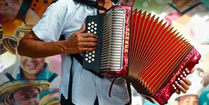 Hombre con un acordeón extendido en el pecho