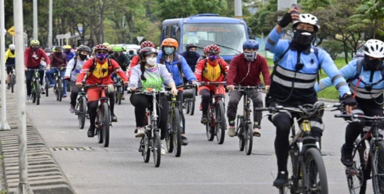 Personas en bicicleta por una de las vías principales de la ciudad