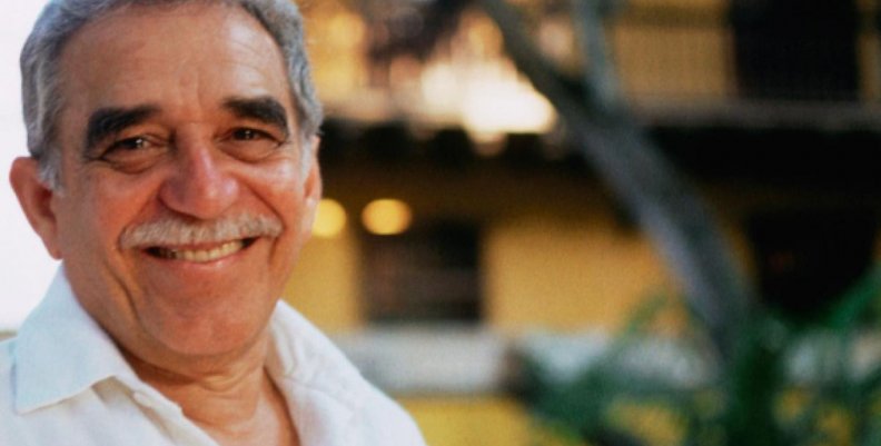 Gabriel García Márquez posando frente a una casa amarilla