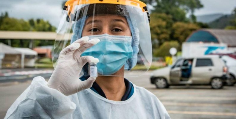 Personal médico mostrando una dosis de una vacuna contra covid-19