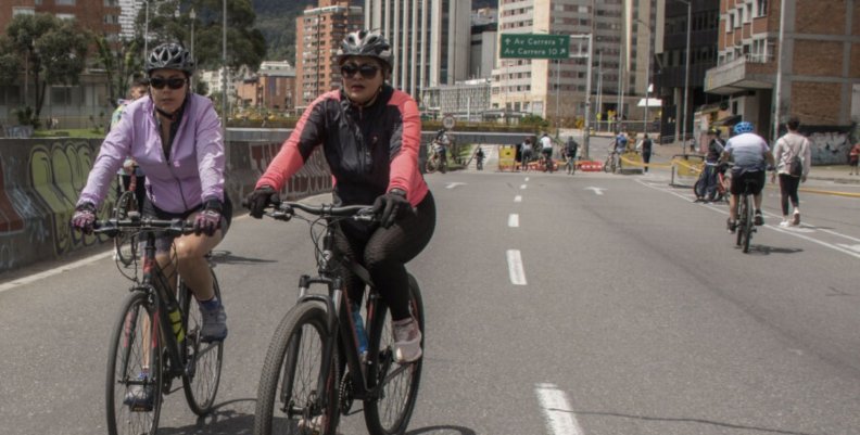 Mujeres en bicicleta recorriendo una de las vías principales de la ciudad durante la ciclovía