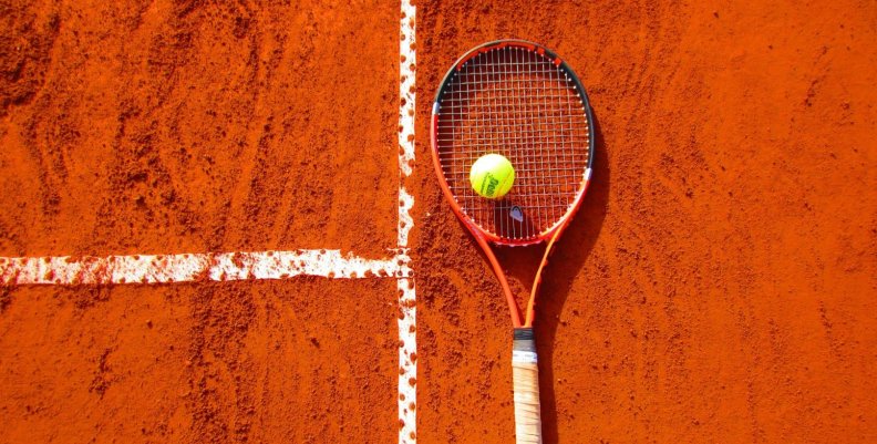 Cancha de Tenis en polvo de ladrillo con un raqueta y pelota 