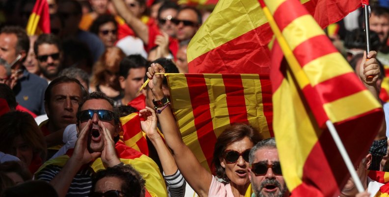 People wave Spanish and Catalan flags as they attend a pro-union demonstration organised by the Catalan Civil Society organisation in Barcelona