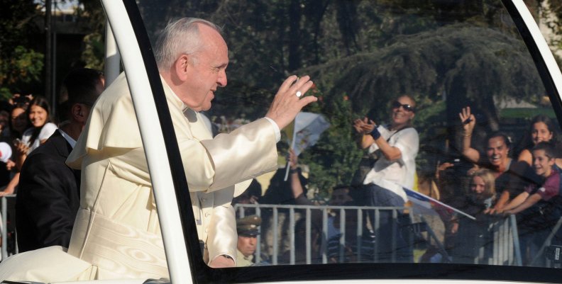 Pope Francis waves while driving through Santiago