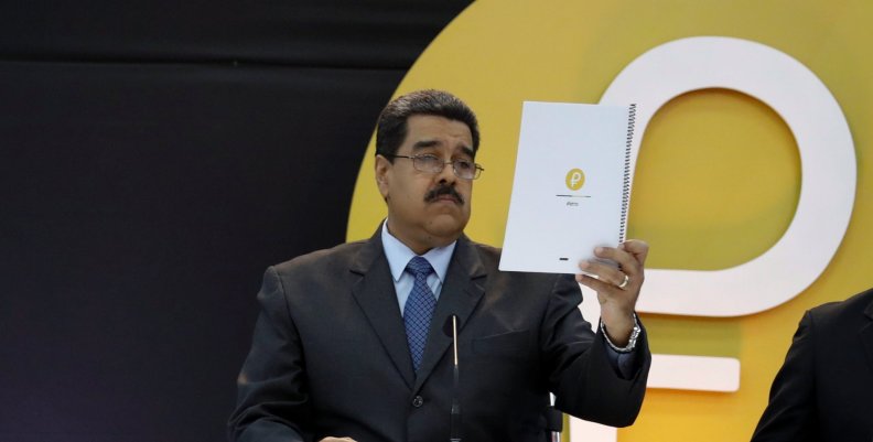 Venezuela's President Nicolas Maduro reads a document during the event launching the new Venezuelan cryptocurrency "Petro" in Caracas