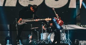 Un hombre tocando guitarra en una tarima