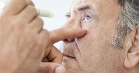 Hombre con el ojo abierto. Van a aplicarle gotas 