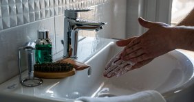 Grifo de agua y manos enjabonadas 