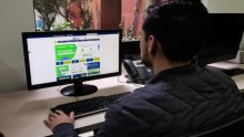 Un hombre sentado frente a un computador 