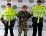 Dos oficiales de Policía, con un hombre capturado vestido con uniforme militar