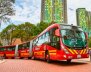 Bus de TransMilenio, color rojo, rodando por la calle 