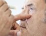 Hombre con el ojo abierto. Van a aplicarle gotas 