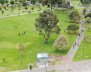 Vista aérea de un parque de Bogotá con zonas verdes y un pasillo de tránsito. 