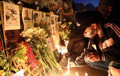 Un grupo de jóvenes prende velas este jueves en las calles del barrio Verbenal como protesta por la muerte de manifestantes en Bogotá.