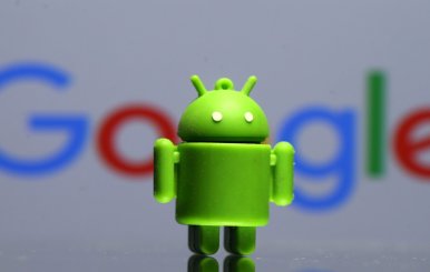 A 3D printed Android mascot Bugdroid is seen in front of a Google logo in this illustration