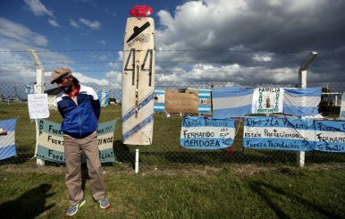 A man stands in front of signs in support of the missing crew members of the ARA San Juan submarine in Mar del Plata