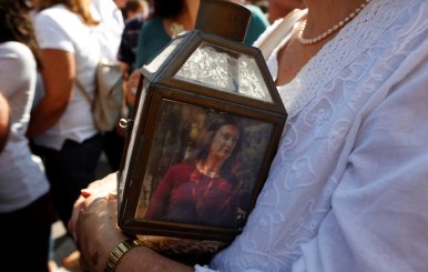 A woman holds a lantern with a picture of investigative journalist Daphne Caruana Galizia, who was assassinated in a car bomb attack, during a protest outside the law courts in Valletta