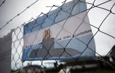 An Argentine national flag with messages in support of the 44 crew members of the ARA San Juan submarine missing at sea is seen placed on a fence at the Argentine Naval Base where it sailed from, in Mar del Plata