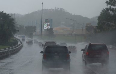 Cars drive on a highway during rain before the arrival of the Hurricane Maria in San Juan