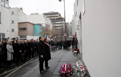 French President Emmanuel Macron and Paris mayor Anne Hidalgo observe a minute of silence outside the satirical newspaper Charlie Hebdo former office in Paris