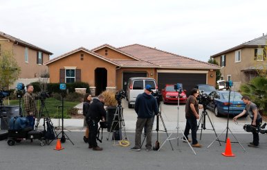 Members of the news media stand outside the home of the Turpins in Perris