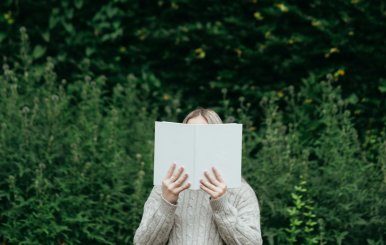 Mujer leyendo un libro en medio de un bosque