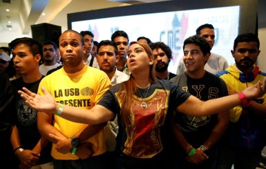 Opposition supporters react while listening to the results of the nationwide election for new governors in Caracas