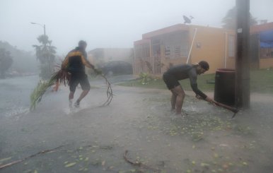 People pick up debris as Hurricane Irma howled past Puerto Rico after thrashing several smaller Caribbean islands, in Fajardo