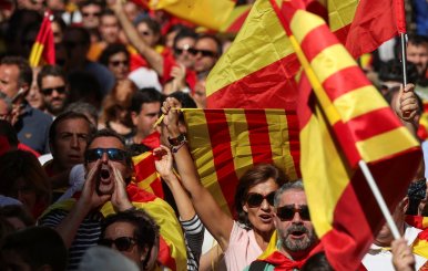 People wave Spanish and Catalan flags as they attend a pro-union demonstration organised by the Catalan Civil Society organisation in Barcelona