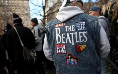 Un hombre usa una chaquete con un mosaico de imágenes de los Beatles en el sector Strawberry Fields del Parque Central de Nueva York