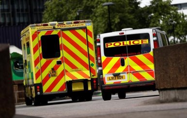 Una ambulancia espera junto a una camioneta policial fuera del departamento de emergencias del Hospital St Thomas, en Londres