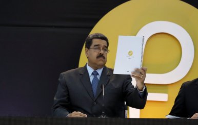 Venezuela's President Nicolas Maduro reads a document during the event launching the new Venezuelan cryptocurrency "Petro" in Caracas