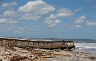 Women walk on a damaged beach access ramp after Hurricane Irma passed the area in Ponte Vedra Beach