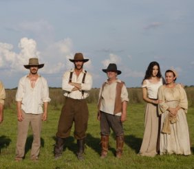 Cuatro hombres y tres mujeres vestidos con ropa antigua del campo