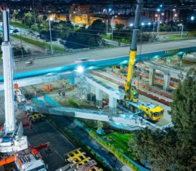 Un puente vehicular de concreto, rodeado de maquinaría de obra