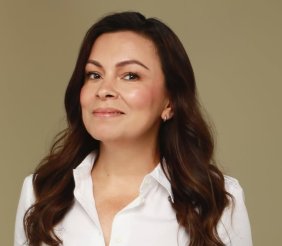 Una mujer sonriente con camisa blanca